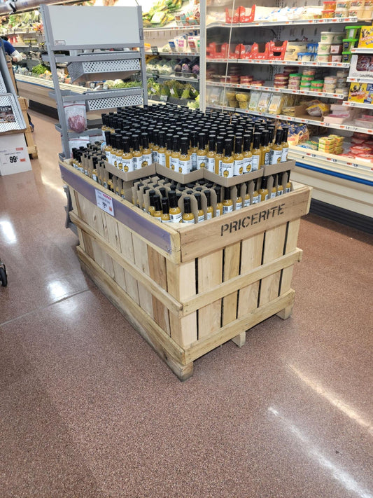 A picture of Sauce Bae Skinny Hotter Habanero Hot Sauce Made With Turmeric showing in a crate in the middle of a grocery store.