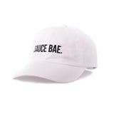 Angled view of white dad hat with white embroidered 'Sauce Bae' logo on the front. Perfect for fans of Sauce Bae, a health-focused hot sauce and raw honey brand